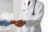 Doctor shaking hands with patient in hospital, closeup